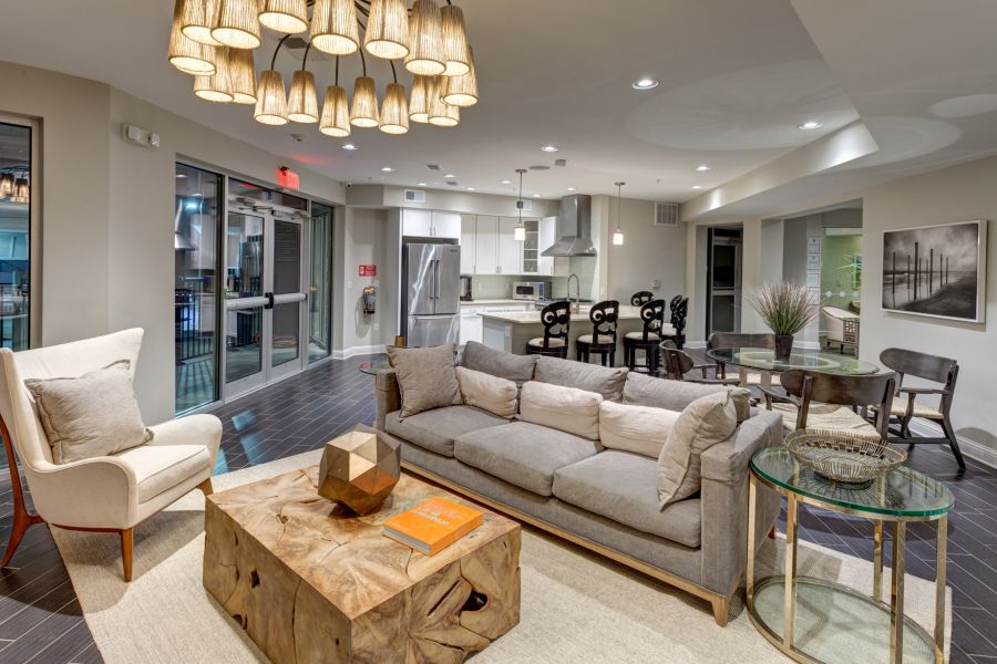 Modern open-concept living room and kitchen with neutral decor, stylish lighting, and cozy seating areas.