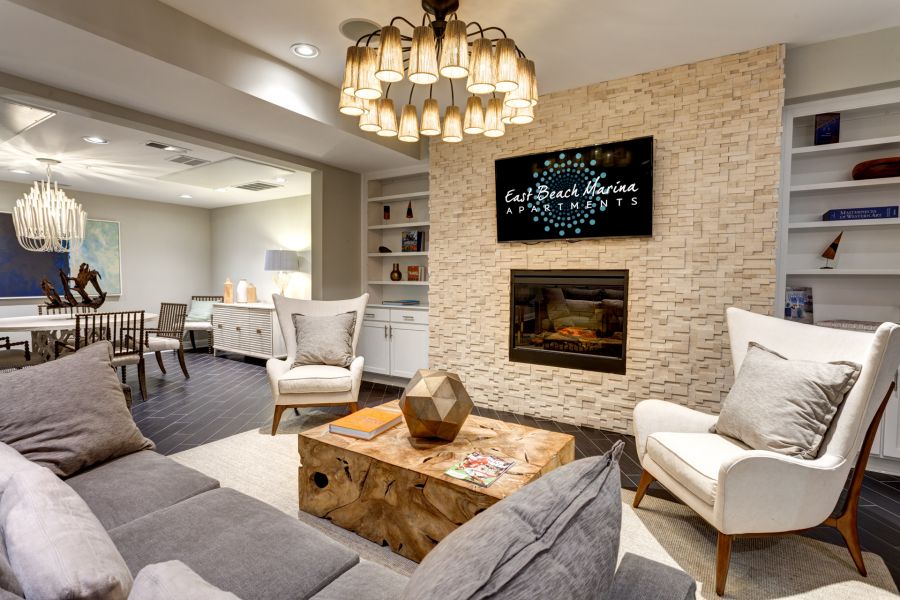 Modern living room with neutral tones, a fireplace, TV, wood coffee table, and cozy seating.